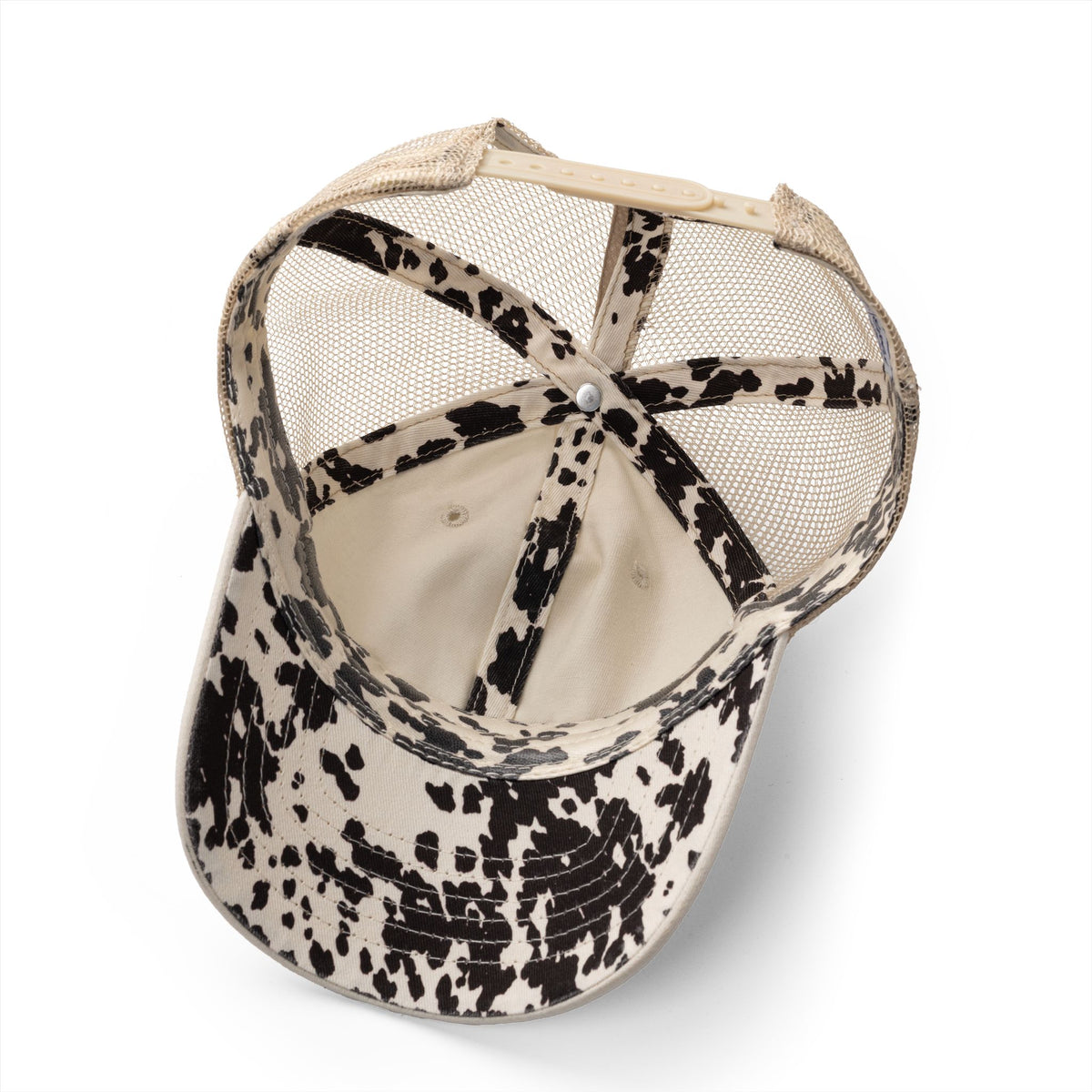 Baseball cap with black and white cow print pattern on a white background